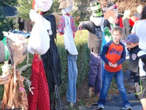 Alex, 7, and Jack, 8, view entries in the scarecrow contest in front of the Community House.