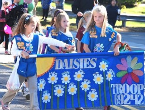 Members of Daisies Troop 69242 carry their banner.