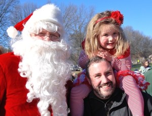 Santa gets his photo taken with Scarlet Spencer, 4, and her father Mathew.