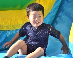 Rio Takekawa, 4, reaches the bottom of a giant inflatable slide. 