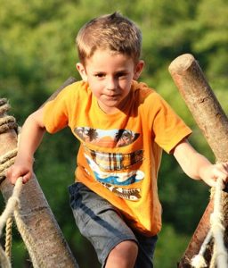 Milo Holtschlag, 6, challenges himself to cross the rope bridge offered by Boy Scout Troop 1. 