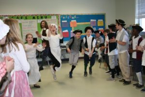 Students in Colonial dress try traditional courting dances.
