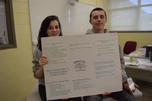 Georgia Faddoul and Jared Rego hold up their poster and mindfulness cards for their campaign, “Branch Out Above Bullying.”