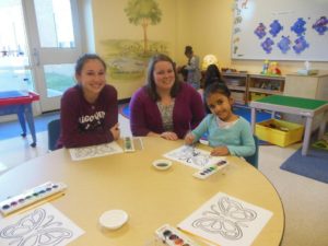 Sophomore Julia Callaghan, Program Director Susan Muise, and Gauri Sharma, 5, work on a project together.