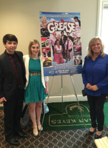 (l t r) Students Chris Boutwell and Lily Plummer with Deb Harper, design and visual lead teacher at Assabet, with a poster they created with photos from the photo shoot.