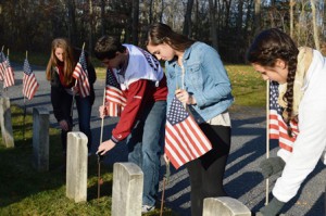 ( l to r):  Maddie French, Dan Boucher, Hanna Spofford, and Meredith Wolpert remove flags from graves of deceased veterans.  Photo/Brent French 