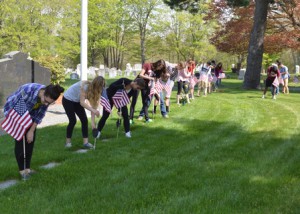 Westborough High School students place American flags next to headstones of local veterans. (Photo/submitted)