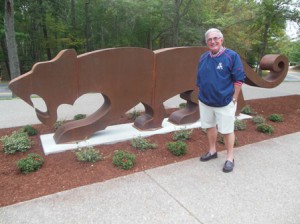 City Council member Don Landers stands before the newly installed Panther sculpture. 