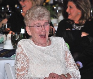 Pat Heald is amused by the antics of her son, Jim, as auctioneer.