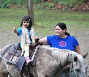 Megha Shah, 3, rides a pony while her mother, Jill, walks alongside.
