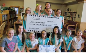 Members of the Shrewsbury Junior Girl Scouts are all smiles as they present a check and cookies to Cherylann Gengel for orphans in Haiti.  Photo/Joyce DeWallace 