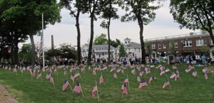 Spectators line Main Street in front of the Heald and Chiampa Funeral Home, which decorated their lawn with many flags in honor of the Memorial Day ceremonies. 