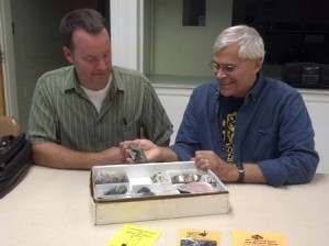 Shrewsbury resident Larry Bull (right) shows off his recent find of babingtonite, Massachusetts’ state mineral, to Gordon Tripp, fellow member of the Worcester Mineral Club. He discovered the mineral at a construction site in Shrewsbury. (Photo/Lori Berkey)