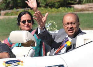 Ketki and Mahesh Reshamwala ride in a convertible as he’s honored as the grand marshal.