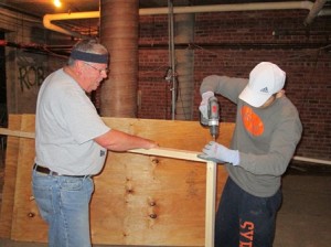 Bill and Matt Ryzewski build a shelf for St. Mary Parish's Refugee Welcome Ministry.