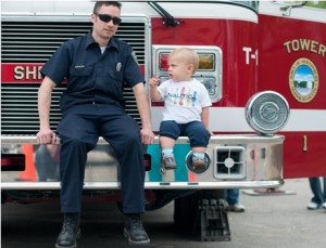 Brady, 17-months-old, sits on the firetruck with his new friend, Shrewsbury firefighter Brendan Palumbo.  