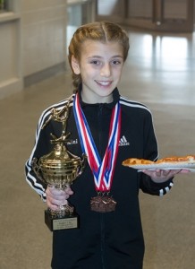 Kaleigh Demarco, 11, from North Attleboro, enjoys a treat after winning the Xcel Platinum Child Third Place All Around.