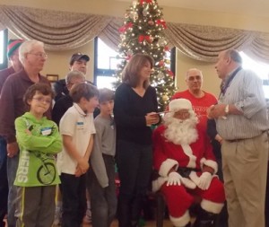 Jennifer Tevekelian and her three boys receive a special Christmas present from Grand Knight John Martello at the Knights of Columbus