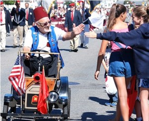 A member of the Worcester County Shrine Club gets a high five from a parade spectator.