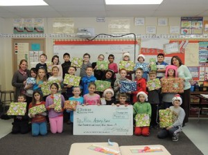 Third-graders at Paton Elementary School display the donation check for needy families at the school. The students raised nearly $500 with help from Clinton Savings Bank. (Photo/submitted)
