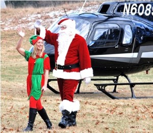Santa's helper, aka Event Chair Pam Higgins, and Santa Claus disembark from the helicopter.
