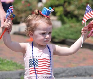 Ila Bartolini, 20 months, gets help marching in the parade.