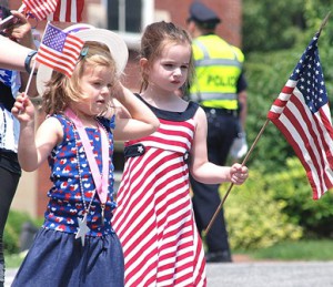 Four-year-old friends Peyton Lohwater and Charlotte Burke wave flags as they march. 