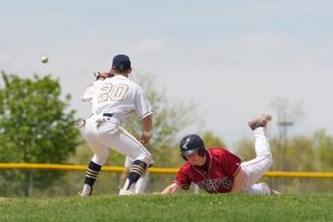 Westborough Ranger's #8 Matty Ruhl slides safely into first base as ing back into first base Shrewsbury's #20 Dillon Zona looks on. 