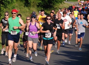Runners turn onto the Assabet River Rail Trail during the Highland City Striders (HCS) annual Running with the Wolves 10K Road Race in 2011. The trail will also be much of the course of HCS's first Fantastic Five Road Race. File photo/Ed Karvoski Jr. 