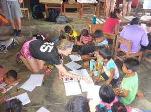Hudson High School student Hannah Carroll helps Peruvian children during last year’s trip to the Amazon Rainforest. (Photo/submitted)
