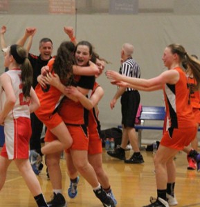Coach Scott McCabe celebrates in the background as Marlborough’s Ciara Shanahan (center) is surrounded after making the game-winning basket at the buzzer in the eighth-grade State Finals.