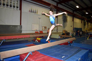 Gianna Ruffing leaps across the balance beam at the New England Academy of Gymnastics.