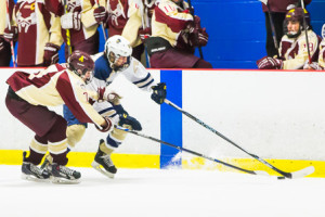 Algonquin’s Jake Alpert (#7) and Shrewsbury’s Anthony Quinlivan (#24) vie for the puck in front of Algonquin’s bench.