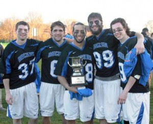 Bryan Parsons (far right) with his Becker College teammates celebrates the school’s first ever New England Collegiate Conference Men’s Lacrosse Championship. 
