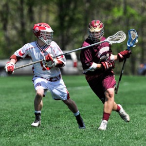 Algonquin Regional High School's Paul Luongo (#28, right) tries to move against the stick of St. John's High School defender Anthony Iandoli (#18, left).