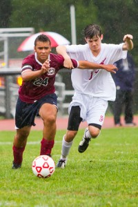 Westborough's striker Lucas Silva (#24, red) and St. John's mid-fielder Aiden Lucey (#17, white) race for the ball.