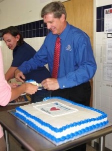 James C. Garvey, president and CEO of St. Mary's Credit Union, serves cake to a Whitcomb Middle School faculty member during a Random Act of Kindness. Photo/submitted
