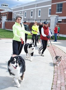 Pet owners and their pooches run the approximately 1.5-mile Doggie Dash. Katie Giroux (left) and her Australian shepherds Scout and Jack placed first overall in 10:54.