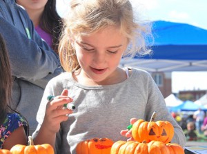 Grace Burke, 6, paints a pumpkin at the Kids Corner.