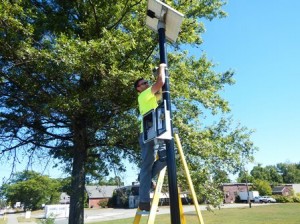 Greg Giroux,of Central Mass. Signal, installs one of the solar-powered laser poles. 