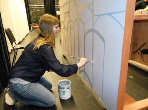 Jessica Olson, part of the crew, puts some finishing touches on part of the set. 