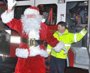 Santa is escorted from Engine 3 by Lt. Ed Manion.