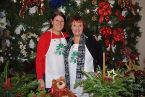Carol DeMichele and Kim Roche, members of the Women's Fellowship of the Congregational Church help out at the Evergreen Fair selling beautiful greens, wreaths and more. 