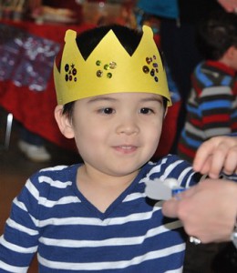 Aaron Bubriski, 4, gets an ornament after learning about the Latin American celebration of Three Kings Day and creating a crown. 