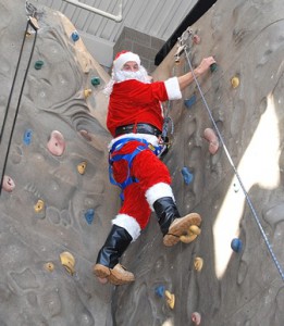 Santa reaches the top of the rock wall.