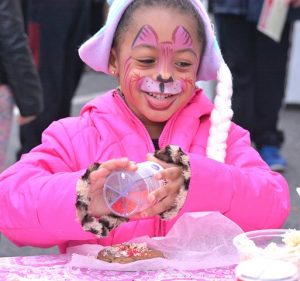 After Laurel Dennis, 4, gets her face painted, she decorates a cookie.