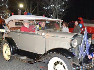Westborough Siloam Lodge of Masons members ride along West Main Street in a classic vehicle decorated with lights.