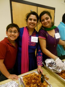 Fifth-grade student Rounak Dey, his mother, Mausumi Dey, and Joyeeta Gangopadhyay help out at the food table.