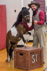 “Sneakers” is escorted into the Westborough High School by Craig McCoskery of Acorn Acres to make a big announcement to the graduating class of 2016. 