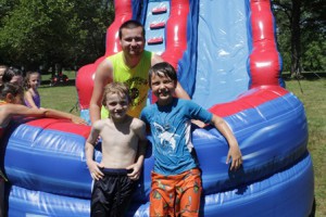 Aiden Lenahan-Steele (left) and Noah Nourse hang out by the waterslide with counselor Jeff Rawson.